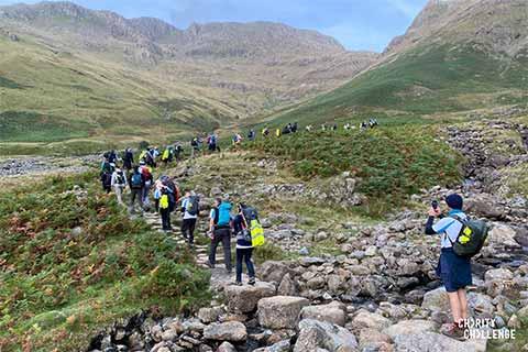 Trekkers participating in an organised charity event through the peaks of the Lake District.