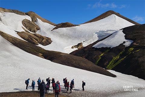 A group of fundraisers gathered at the bottom of Icelandic snowy capped mountains.