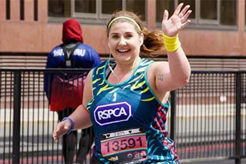 An RSPCA event runner waving.