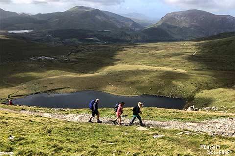 Three trekkers walking through the Snowdonia National Park .
